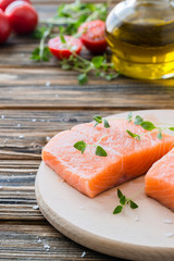 Raw uncooked salmon and vegetables on wooden table