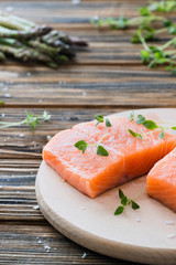 Raw uncooked salmon and vegetables on wooden table