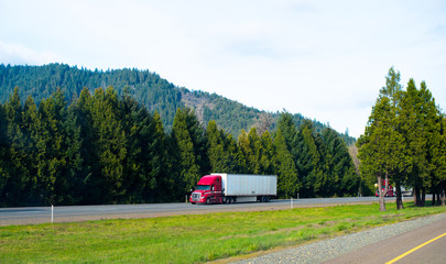 Red semi truck trailer nice rig cargo on green natural road © vit
