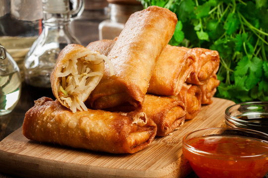 Spring rolls with chicken and vegetables on chopping board