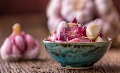Garlic. Fresh garlic bulbs on old wooden board. Red violet garlic. © weyo