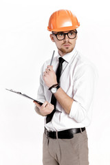 Portrait of young construction engineer in orange helmet with folder on white background