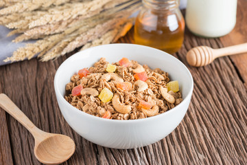 Granola with dried fruits and nuts in white bowl.