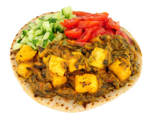 Indian saag paneer cheese meal on a chapati flatbread isolated on a white background