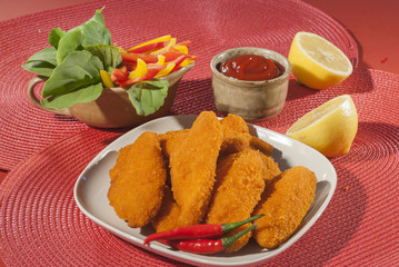 Spicy Breaded chicken fillets with red chilly lemon and cherry tomatoes with ketchup and bell pepper salads