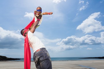 Father holding his son dress like a superhero