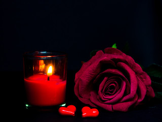 Low key of Valentines Day background-red rose with red candle and two red hearts