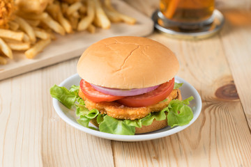 Fast food hamburger with french fries on wooden background.