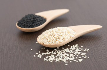 White sesame and black sesame seed on wooden spoon