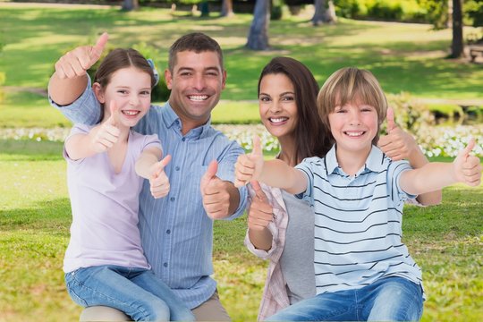 Happy family with thumbs up on garden