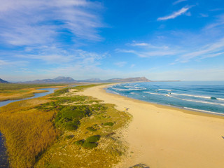 View down the beach with clouds and blue skies