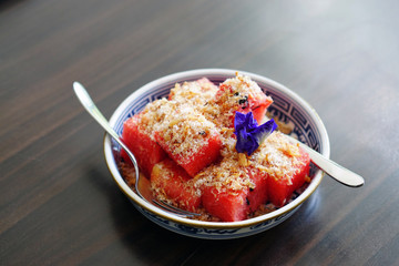 Watermelon with Sweet Dried Fish-Crispy Shallot Dip - Fresh Watermelon chunks thoroughly speckled with a sugary dip of dried fish flakes and crispy shallots, Royal Thai cuisine, Selective Focus.