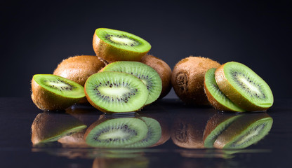 Kiwi on a wet black table .