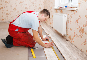 man laying laminate flooring