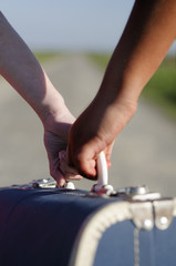 White girl and ethnic girl helps each other carry the suitcase