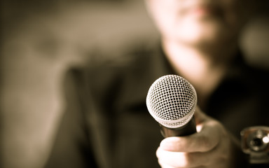 blurred of smart businessman speech, talking with microphone, gray scale tone