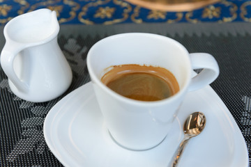 cup of hot coffee and milk on table.