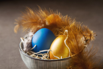 Holiday decoration. Easter egg blue and gold colors. Simple gray background.