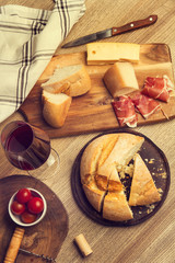 Copa de vino tinto, pan, queso y jamón