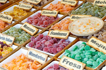 Colorful candied fruits assortment with a signs saying: lemon, watermelon, peach, apple, raspberry, mojito, Mandarin and strawberry.
