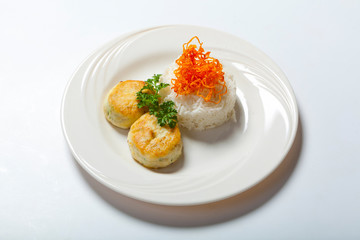cutlets with herbs and rice on a plate. White background