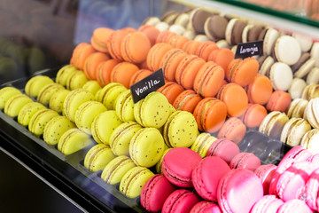 Colorful macarons dessert with a signs saying: Orange and vanilla.