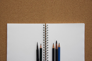 Pencils on openned note book.