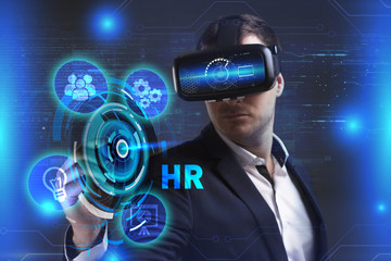 Business, Technology, Internet and network concept. Young businessman working in virtual reality glasses sees the inscription: HR