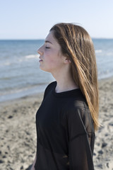 Fototapeta na wymiar Teenage girl with closed eyes isolated on the beach.