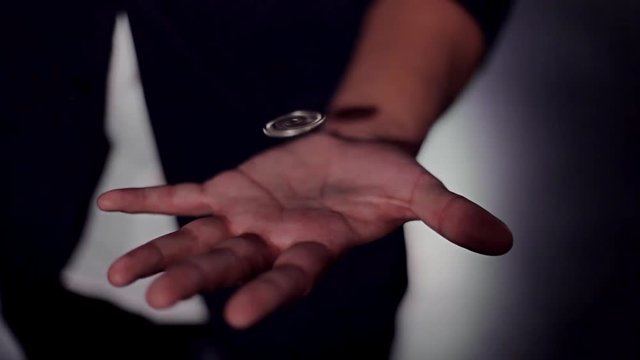 Trick flying coin. Hands of a magician. Levitation