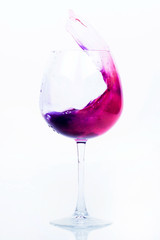 Pink and violet water splashes in a wineglass