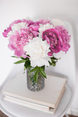 flowers decor, fresh peonies on designer chair in white room int