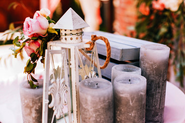 White lantern and black candles stand before blue wooden box