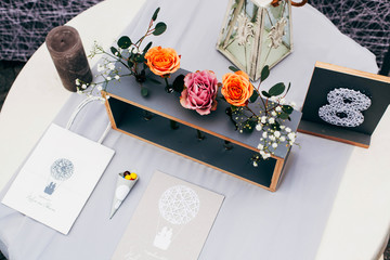 Number eight written on black board stands before board with roses in the center of dinner table