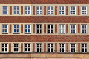 Classic front flat house facade pattern from red brick with white window frame. Old vintage building. Germany