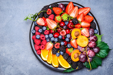 Fresh fruits and berries bowl directly above, text space.