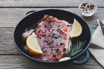 Raw beef steak with spices and herbs.