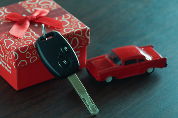 Naklejka premium key of car in gift box on wood table