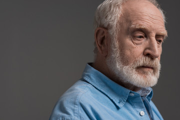 Obraz premium portrait of senior bearded man isolated on grey in studio