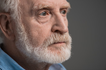 portrait of senior bearded man isolated on grey in studio