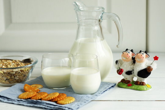 Milk,cookies, granules and toy cows. Funny spotted cows against a background of milk.Breakfast is good for health