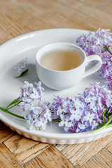 Obraz na płótnie Canvas Lilac flower bouquet, wood desk, white background, morning