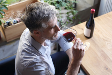 Kieliszek czerwonego wina do obiadu. Mężczyzna pije wino - obrazy, fototapety, plakaty
