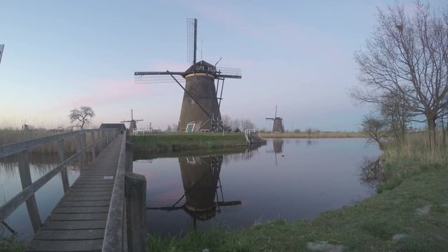 Ancient windmills on riverbank. Beauty of Holland. World most picturesque places. Old engineering constructions.