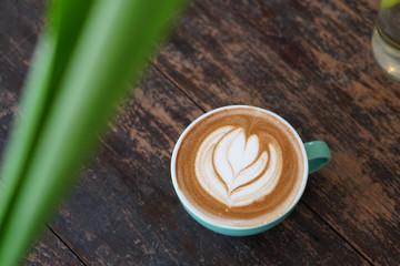 Hot Mocha - Closeup of a cup of coffee with milk and latte art on wooden table background, Morning Breakfast.