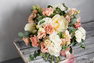 Bridal vintage bouquet. The bride's . Beautiful of mixed flowers and greenery, decorated with silk ribbon, lies on vintage wooden table. vintage style