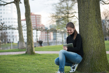 Obraz premium woman with tablet pc in park