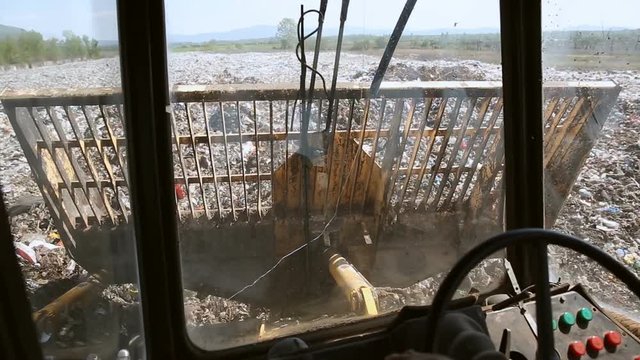 Bulldozer on landfill. View from cabin