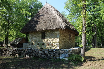 Fototapeta na wymiar House with straw roof in Dimitrie Gusti National Village Museum in Bucharest, Romania 