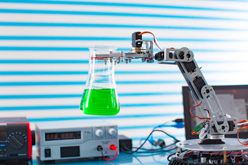 Robot in chemical industry. Roboter arm take test tube with dangerous fluid